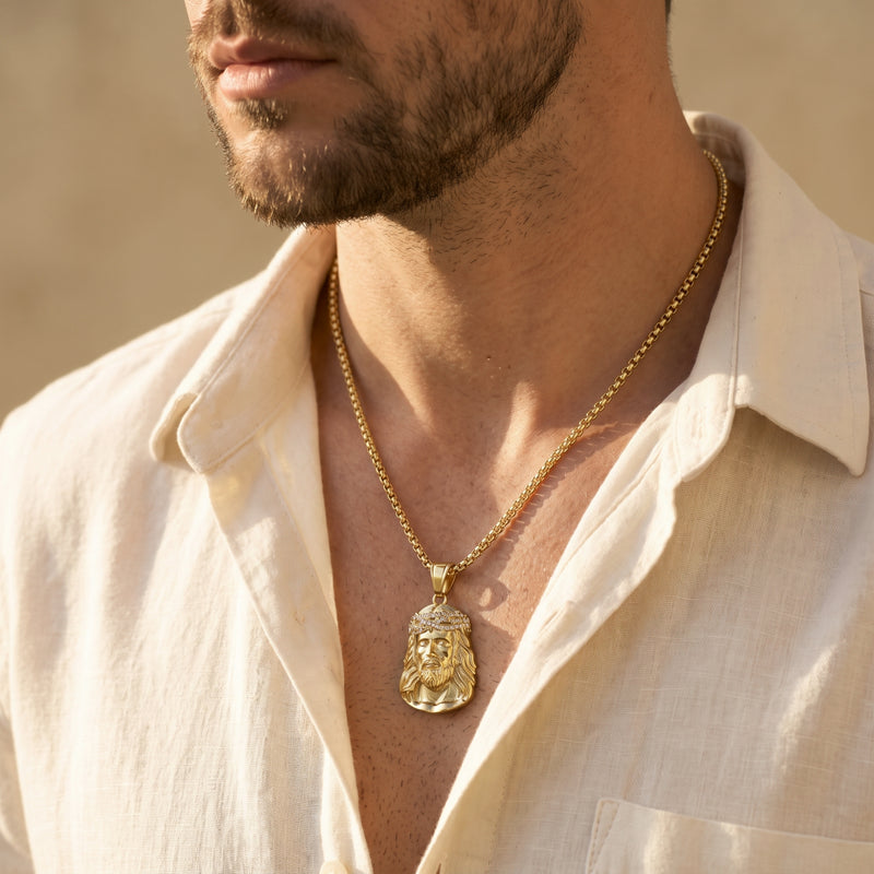 Side-profile view of a man wearing a gold-tone Jesus portrait pendant with an open white shirt.
