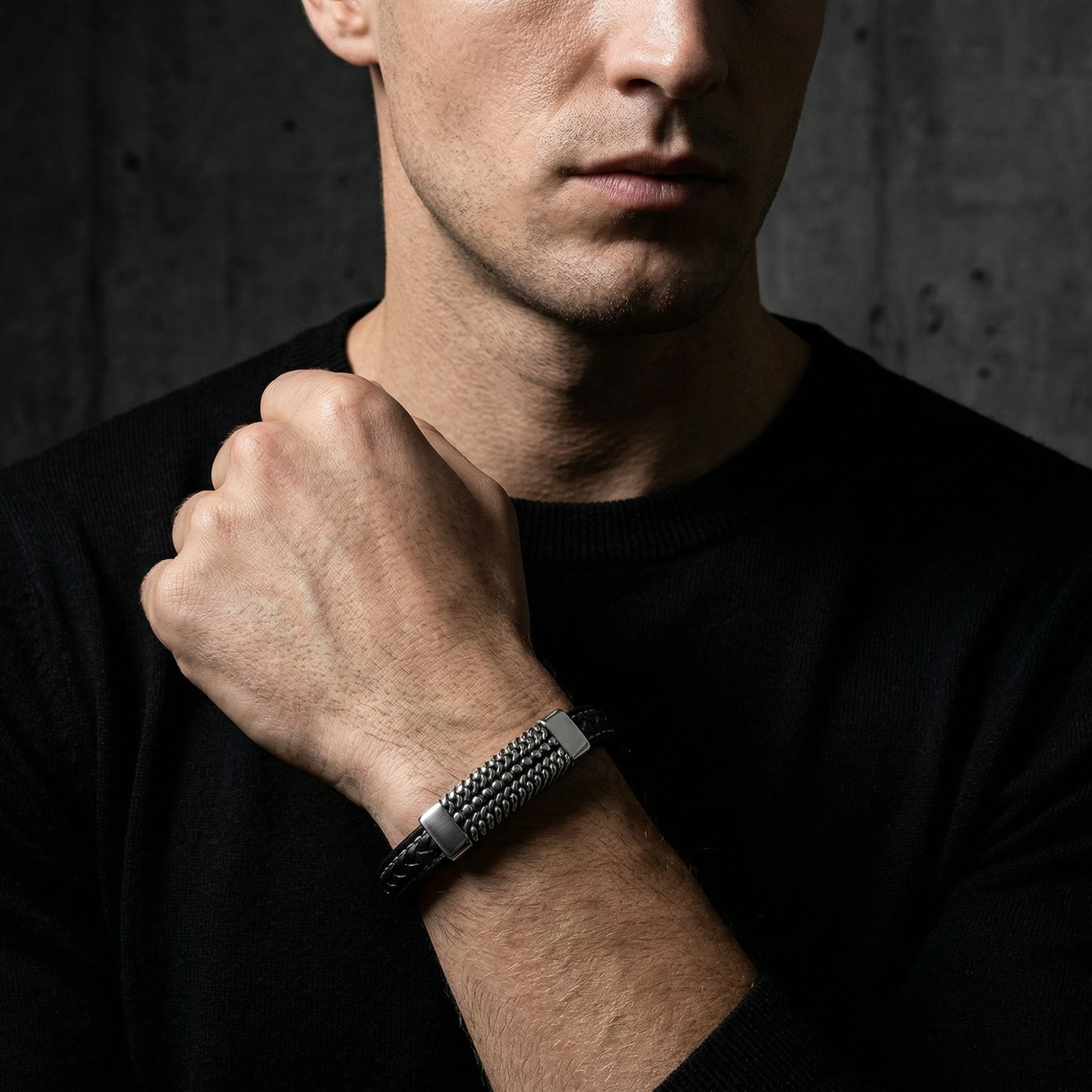 Men's Kinetic Bracelet in black braided leather and silver stainless steel worn on a model's wrist.
