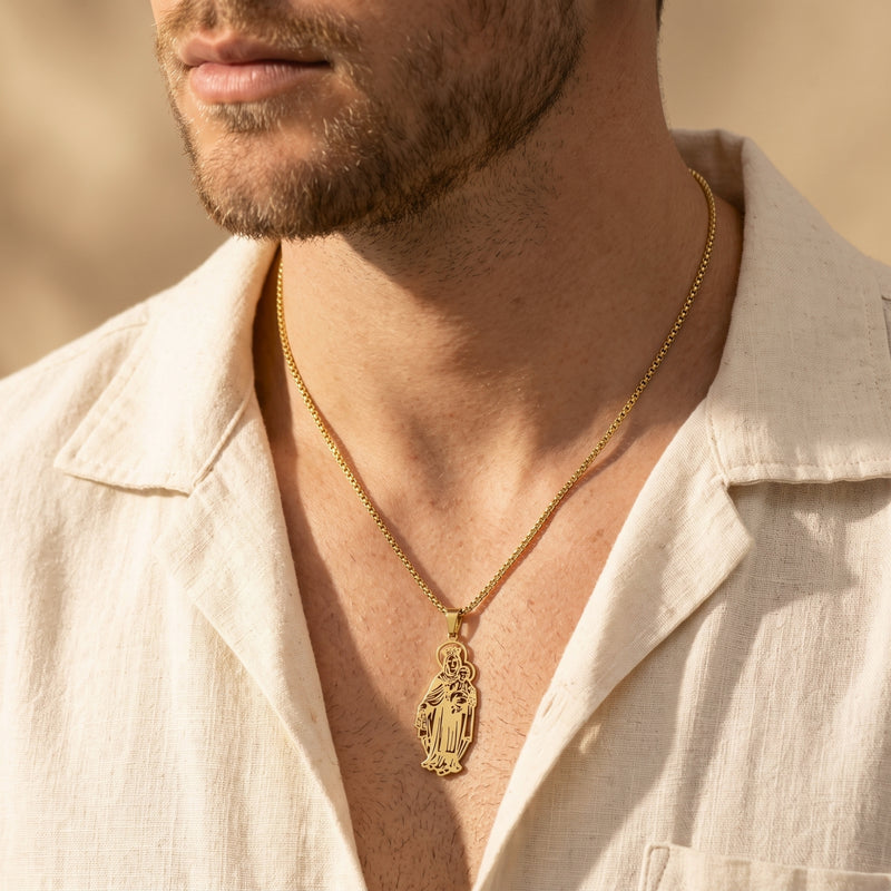 Man wearing a gold Madonna and Child pendant necklace over a cream open-collar shirt.
