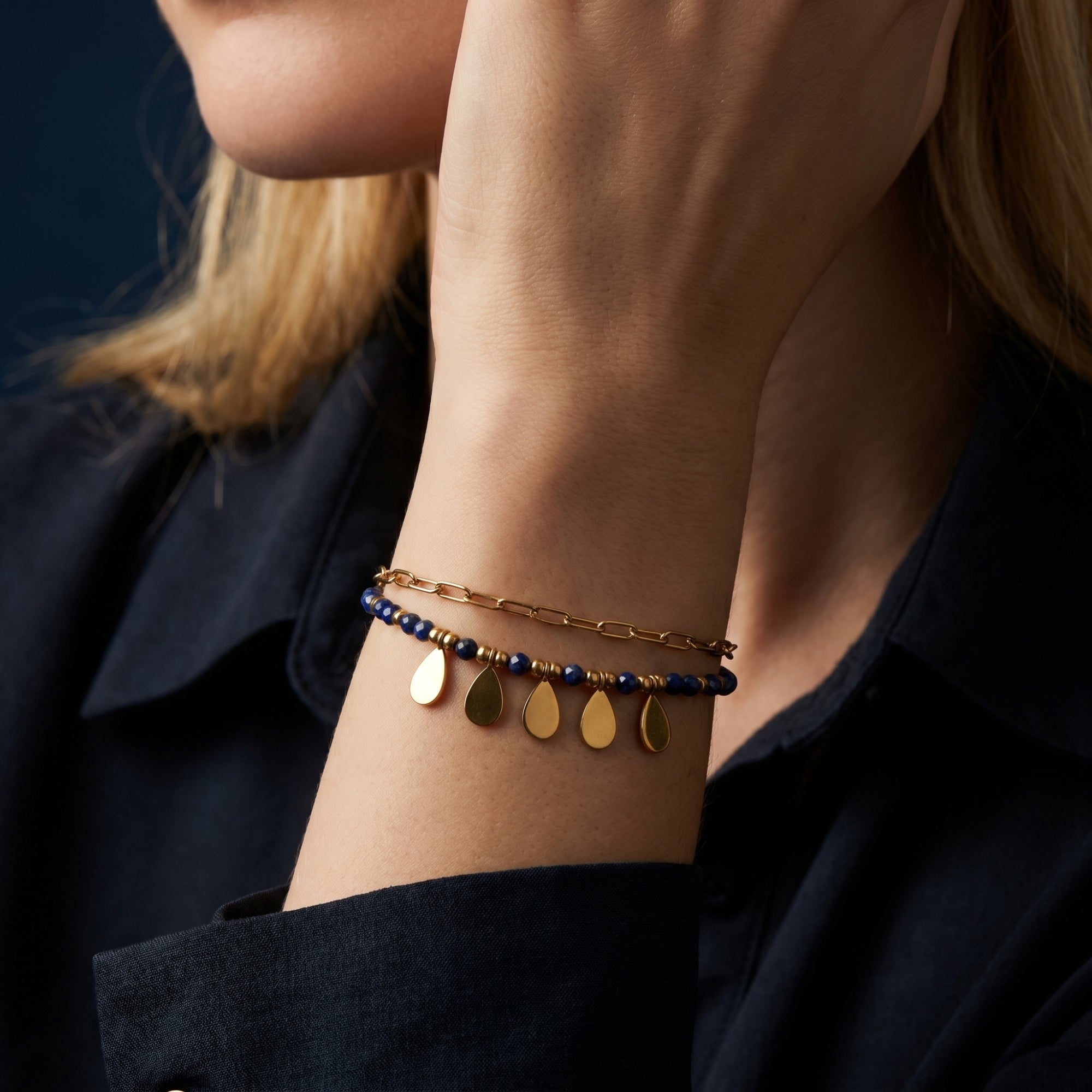 Woman wearing the Sylvan Leaf double-layered 18K gold plated stainless steel bracelet with faceted lapis beads.