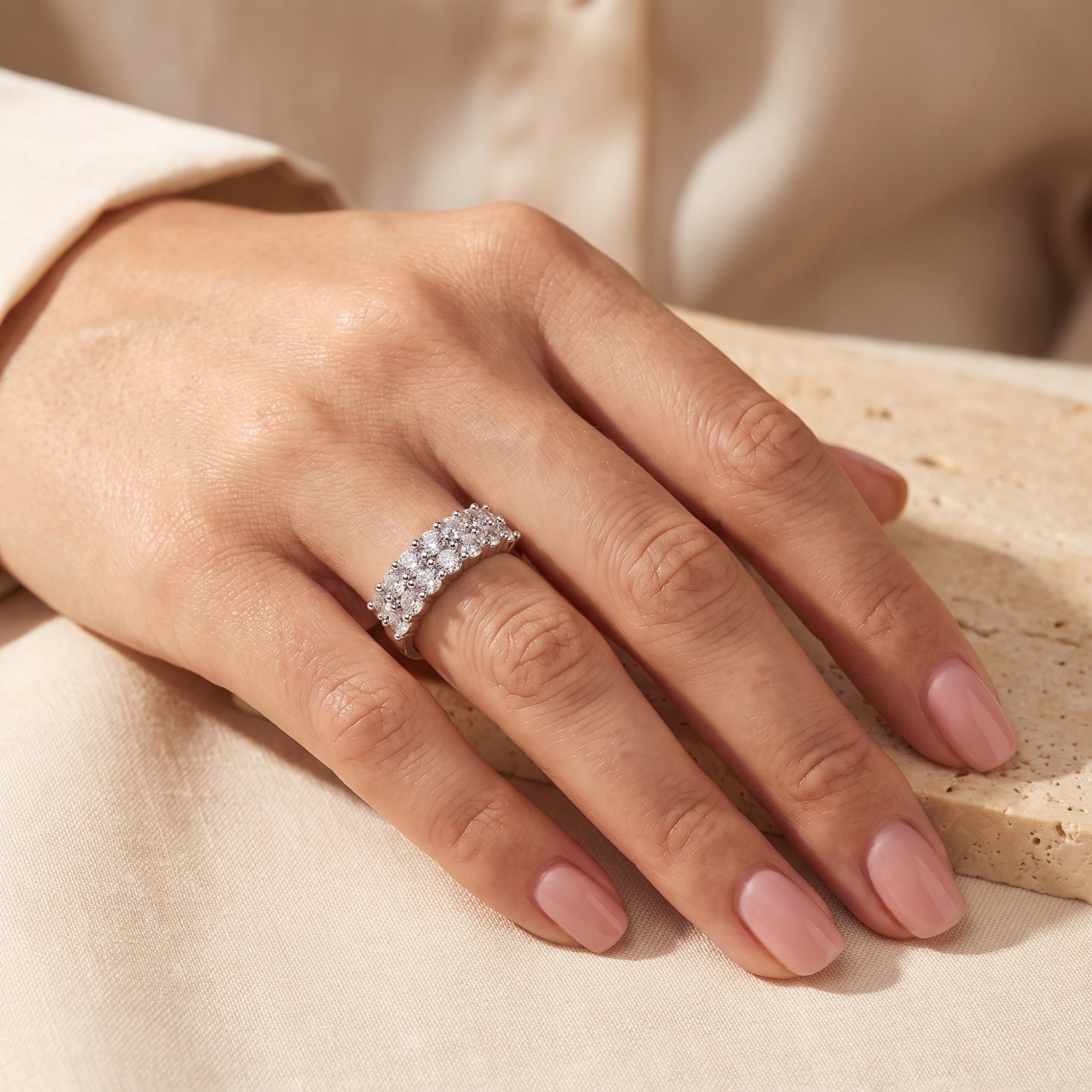 Sterling silver three-row cubic zirconia band ring worn on a hand.