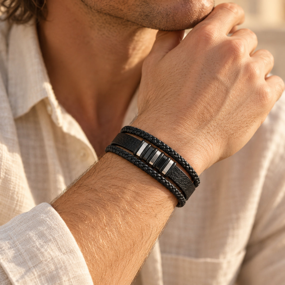 Black layered son bracelet with silver-tone accents worn on a wrist