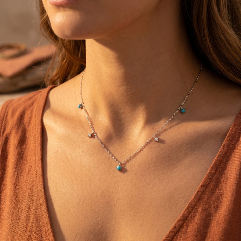 Woman wearing the silver Sedona Horizon necklace with dangling turquoise beads and shimmering star accents.