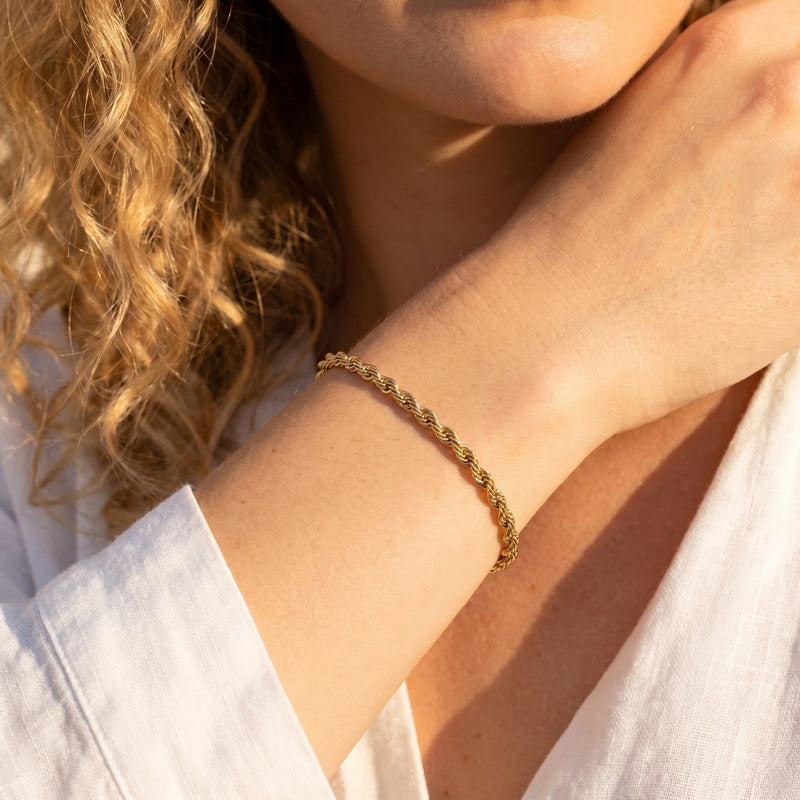 18K gold finish rope chain bracelet worn on a woman's wrist.