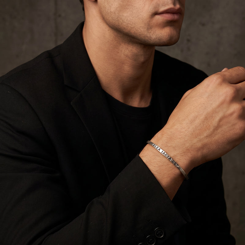 Close-up of a man wearing the engraved silver cuff bracelet with a black jacket.