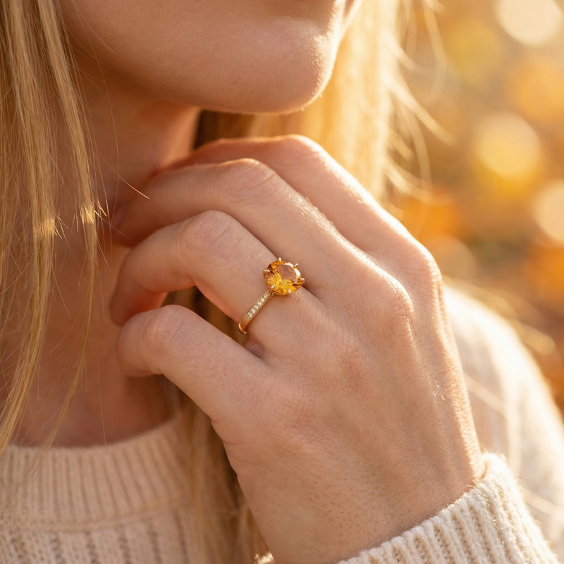 Woman wearing the 18K yellow gold Coronet citrine ring with a round faceted stone on her finger.