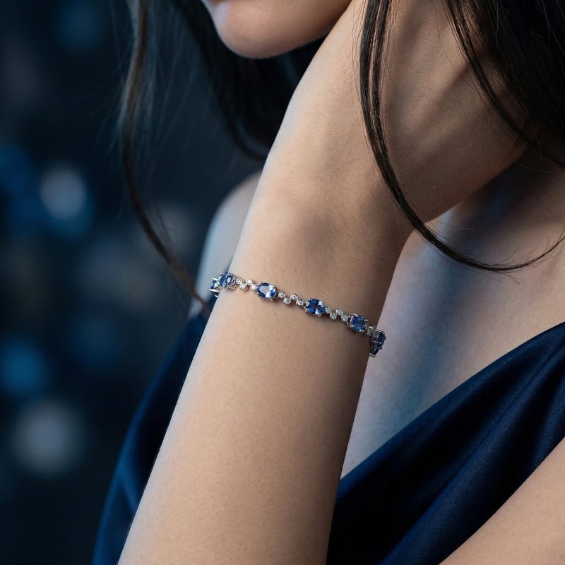 Woman wearing the Carys natural tanzanite station bracelet in sterling silver on her wrist.