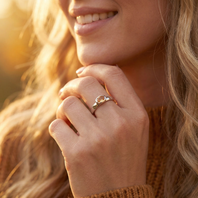 Woman wearing the Marigold citrine ring in sterling silver on her finger in warm outdoor light.