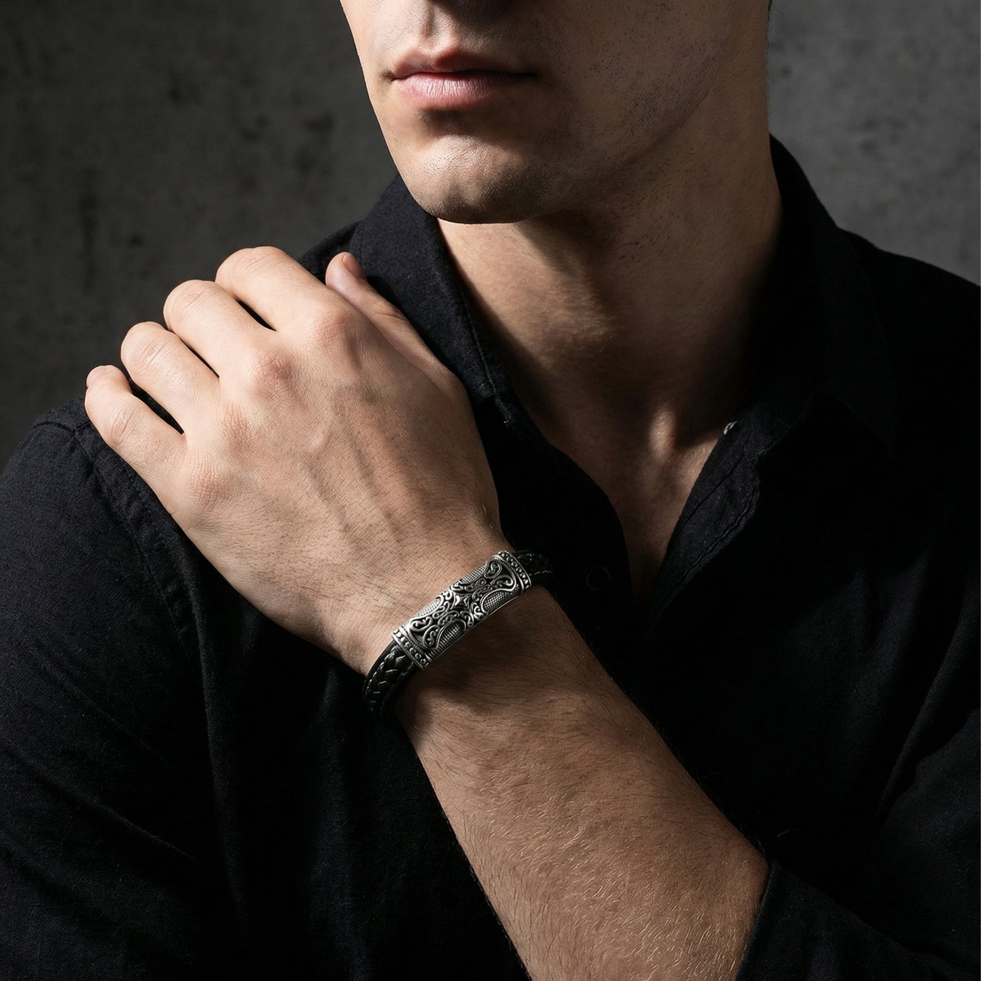 The Runeforge 15mm black braided leather bracelet with a detailed steel clasp worn on a man's wrist.