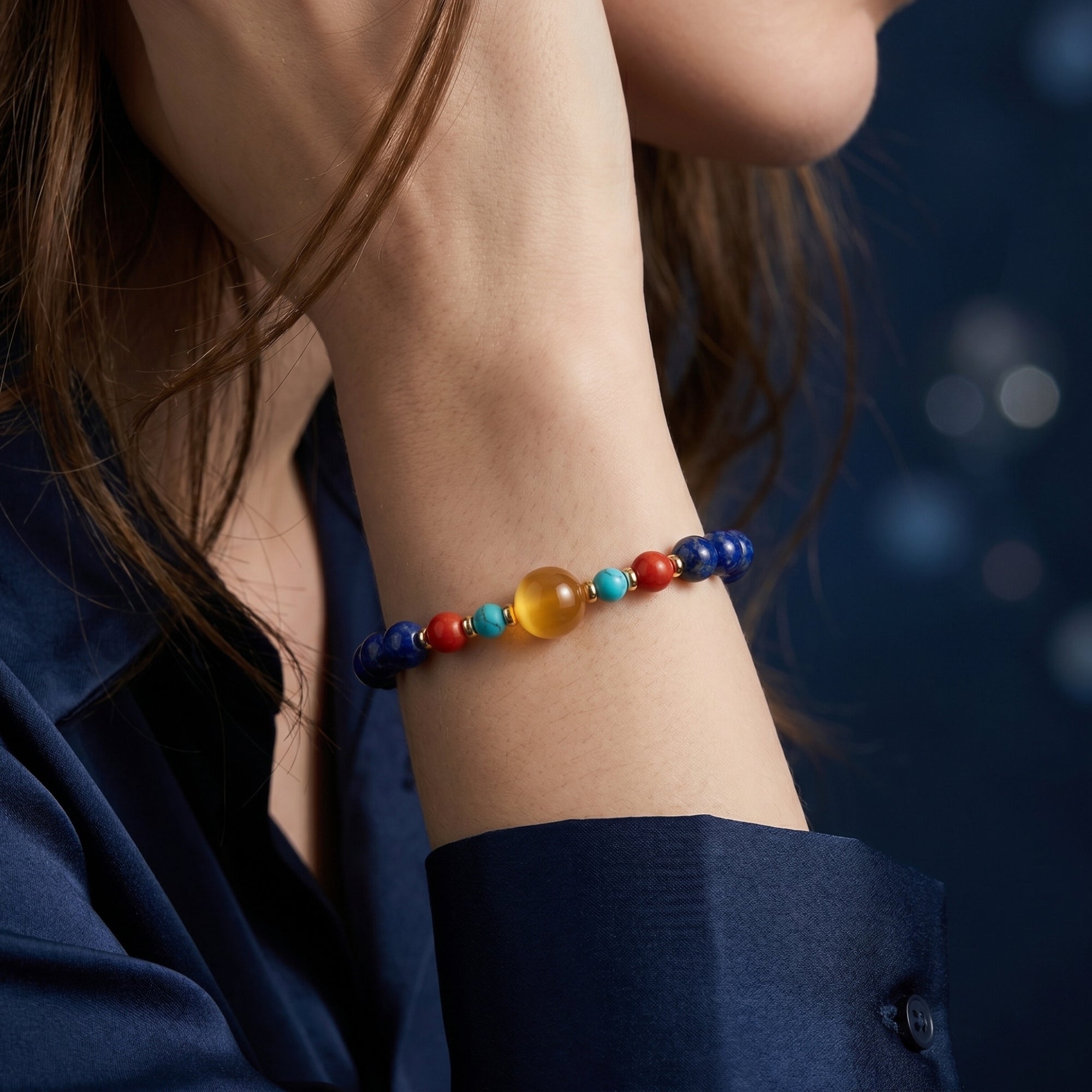 Woman wearing the Azure Glow 6mm lapis lazuli bead bracelet with gold-plated spacers on her wrist.