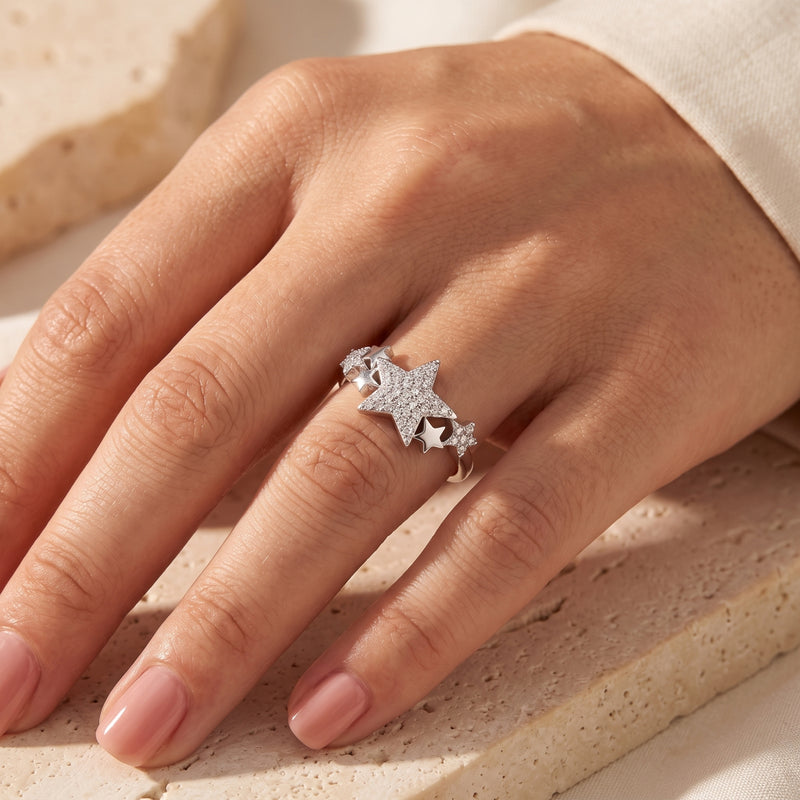 Women's silver star cluster promise ring with simulated diamonds worn on a hand.
