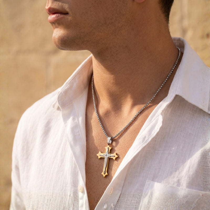 Side-profile view of a man wearing the two-tone cross pendant over an open white shirt.
