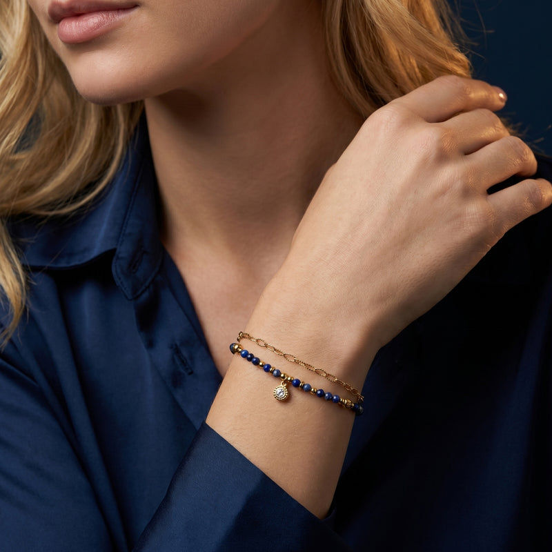 Starlit Station lapis lazuli beaded bracelet in 18k gold plated stainless steel worn on a woman's wrist.