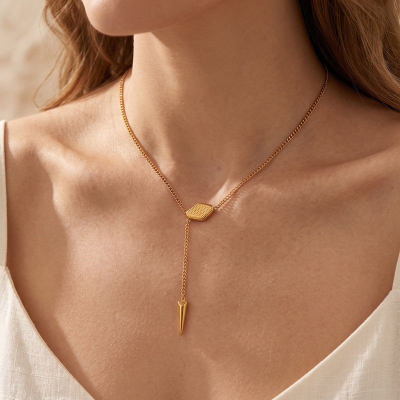 18K gold finish lariat necklace with geometric slider and spike pendant worn by a model.