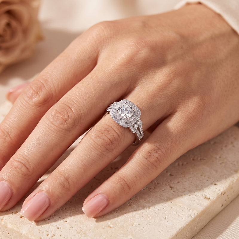 Sterling silver cushion double halo promise ring worn on a hand.