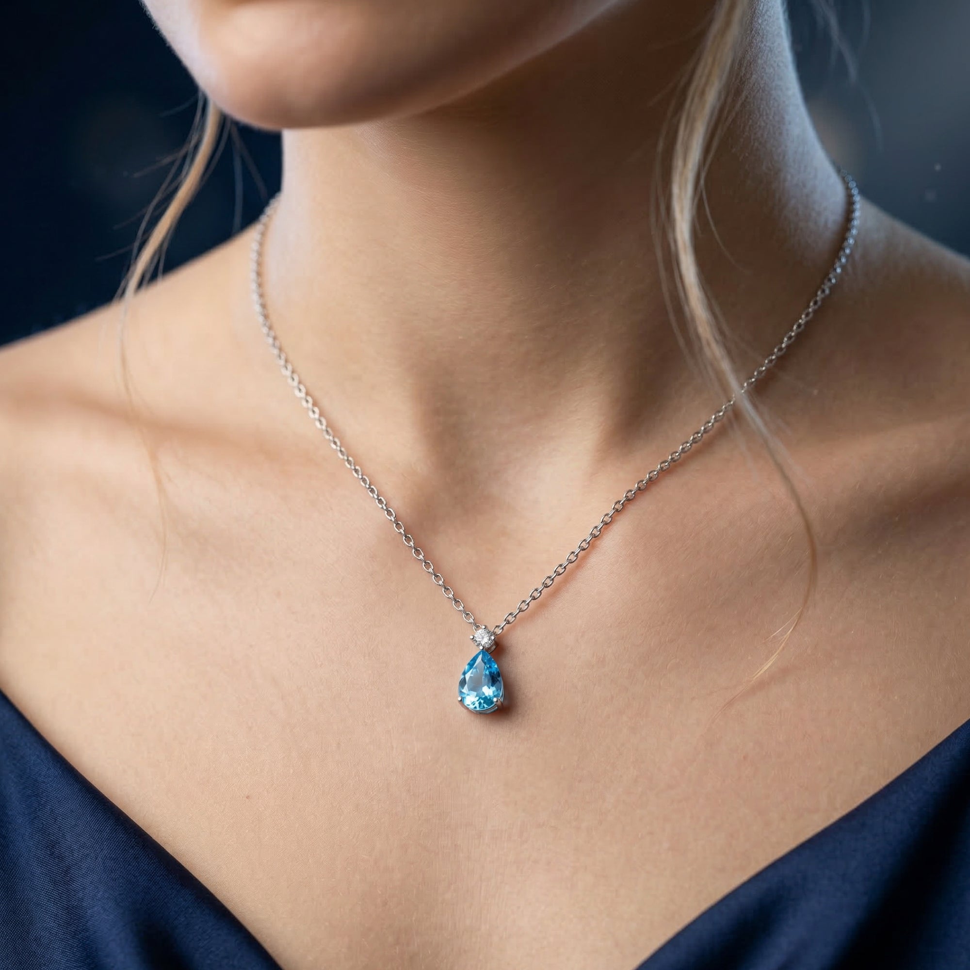 Model wearing the Oceana pear cut natural Swiss Blue topaz pendant necklace in white gold.