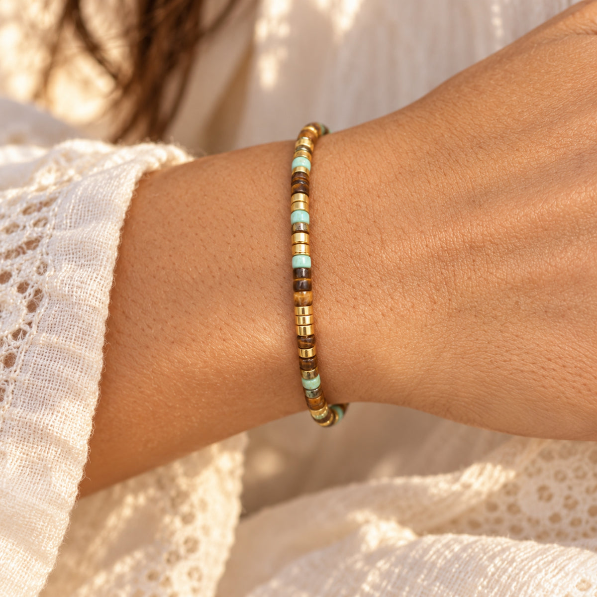 Morse code bracelet with gold-tone spacers on wrist