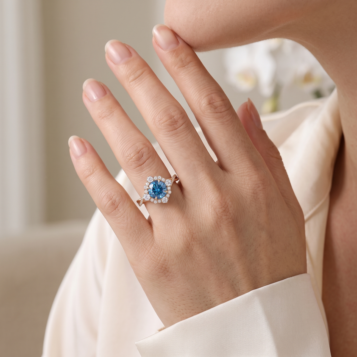 Close-up of a model wearing the rose gold blue moissanite halo ring with a twisted pavé band on her finger.
