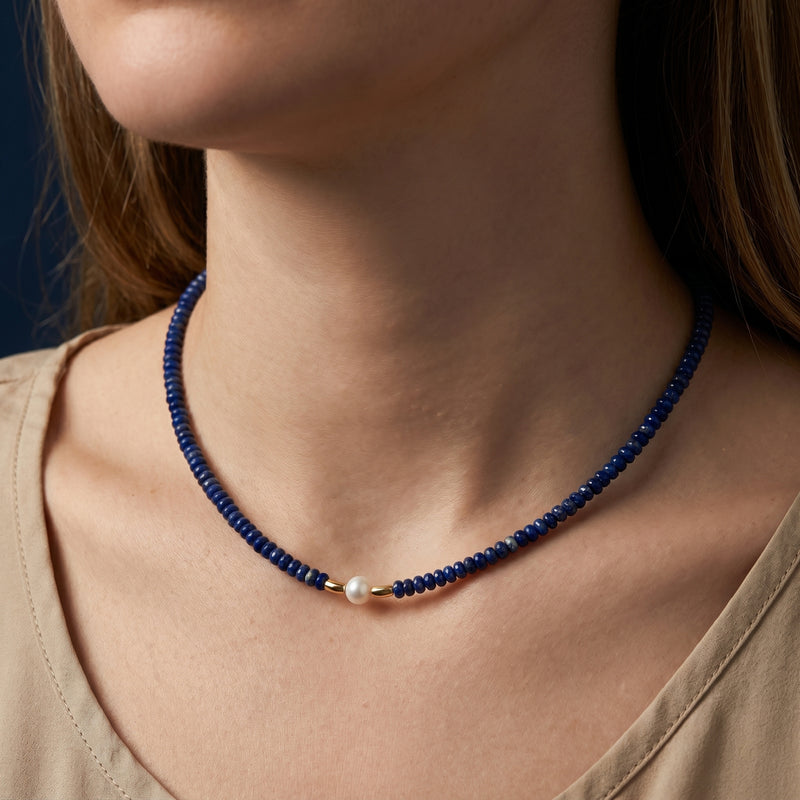 Model wearing the Celestial Strand lapis lazuli beaded necklace with a white pearl and 18k gold plated hardware.