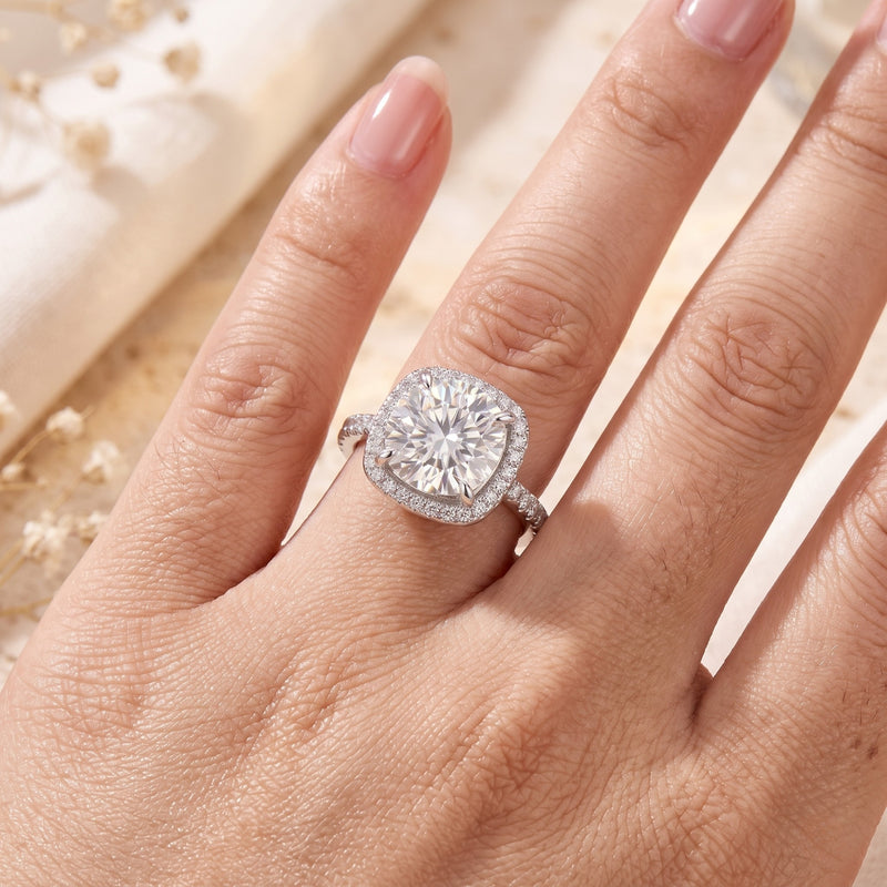 Sterling silver cushion halo promise ring with a round brilliant-cut cubic zirconia worn on a woman's finger.
