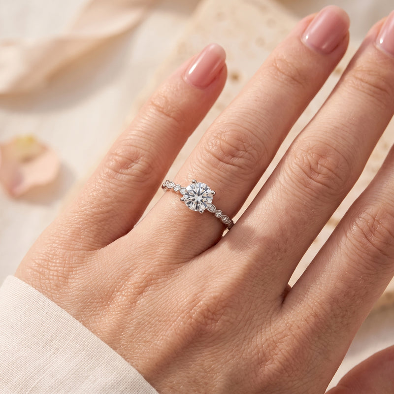Sterling silver promise ring with round cubic zirconia center stone worn on a woman's hand.