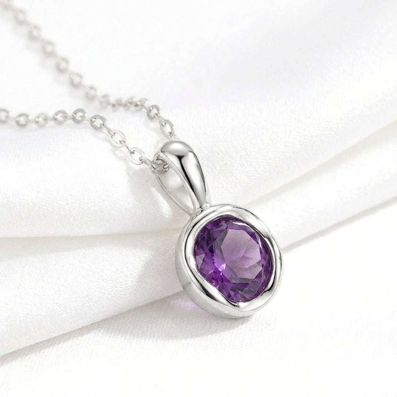 Macro view of the round cut deep royal purple simulated amethyst pendant and sterling silver chain.