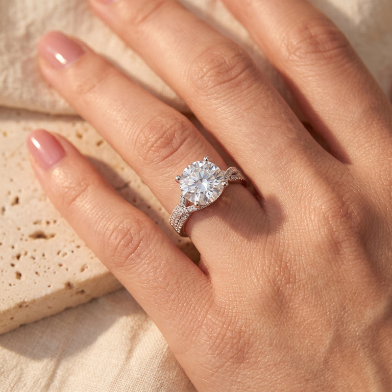 Round cubic zirconia twisted solitaire ring in sterling silver on a hand.