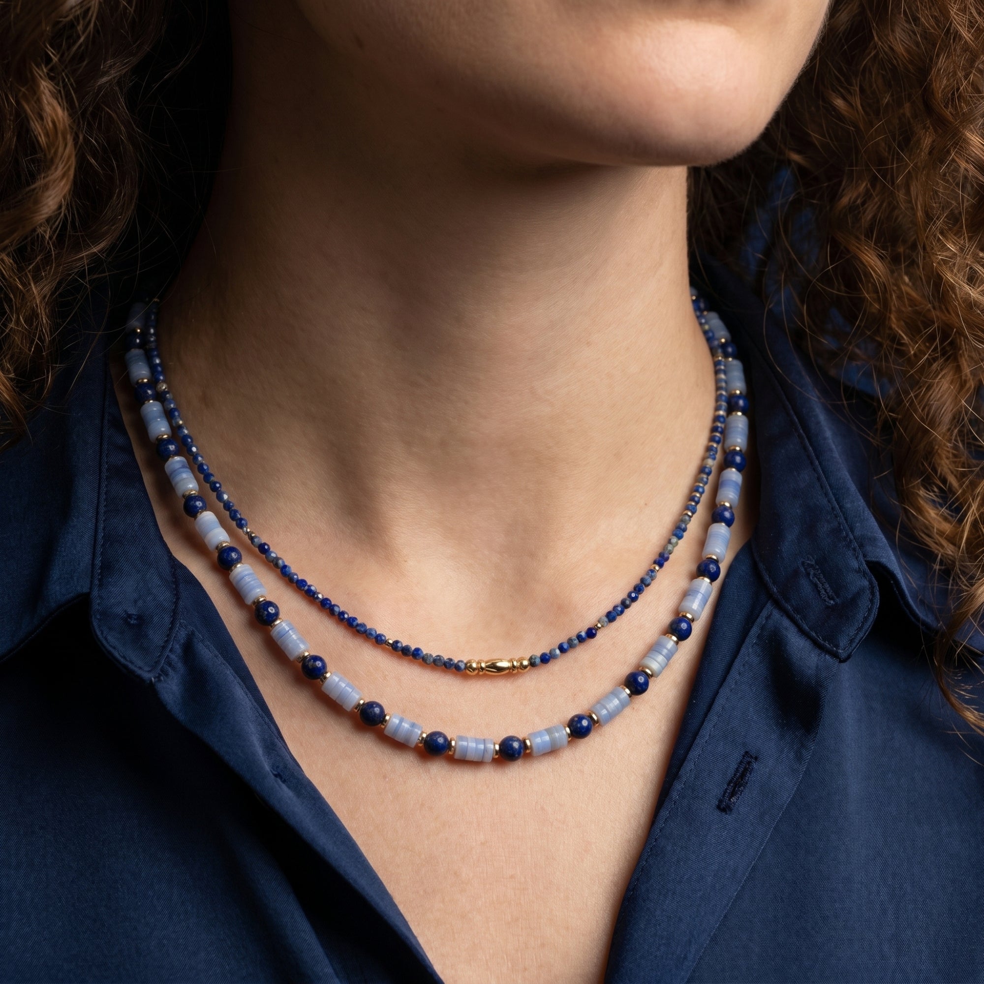 Model wearing the Azure Horizons layered lapis lazuli and light blue bead necklace set with 18k gold plating.