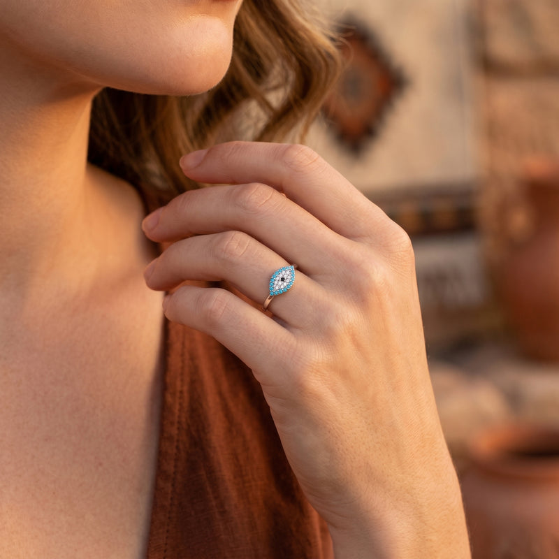 Model wearing the silver Samira turquoise evil eye ring on her finger in a warm, outdoor setting.