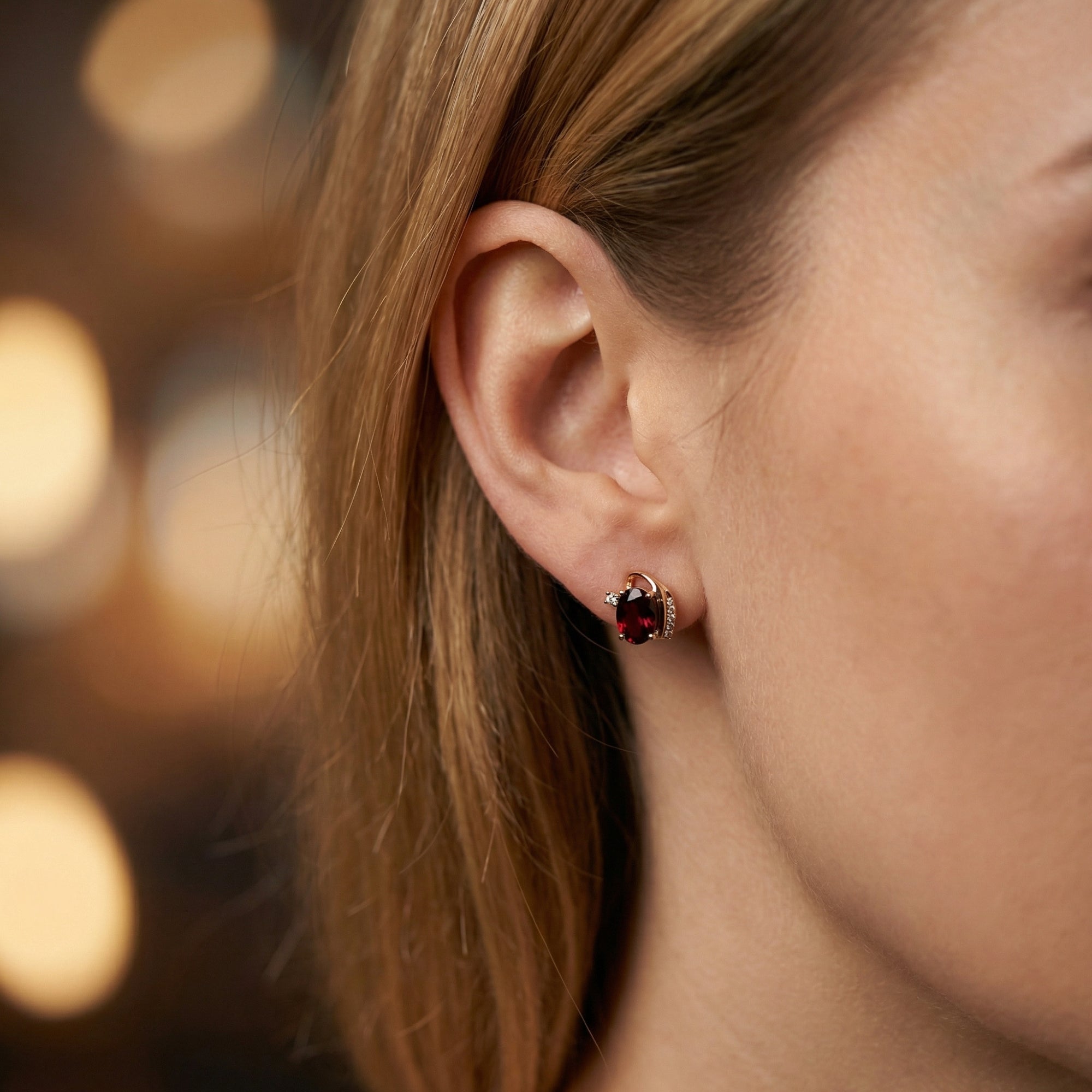 Model wearing a Carisia 18K rose gold drop earring featuring a large oval cut natural garnet and diamonds.