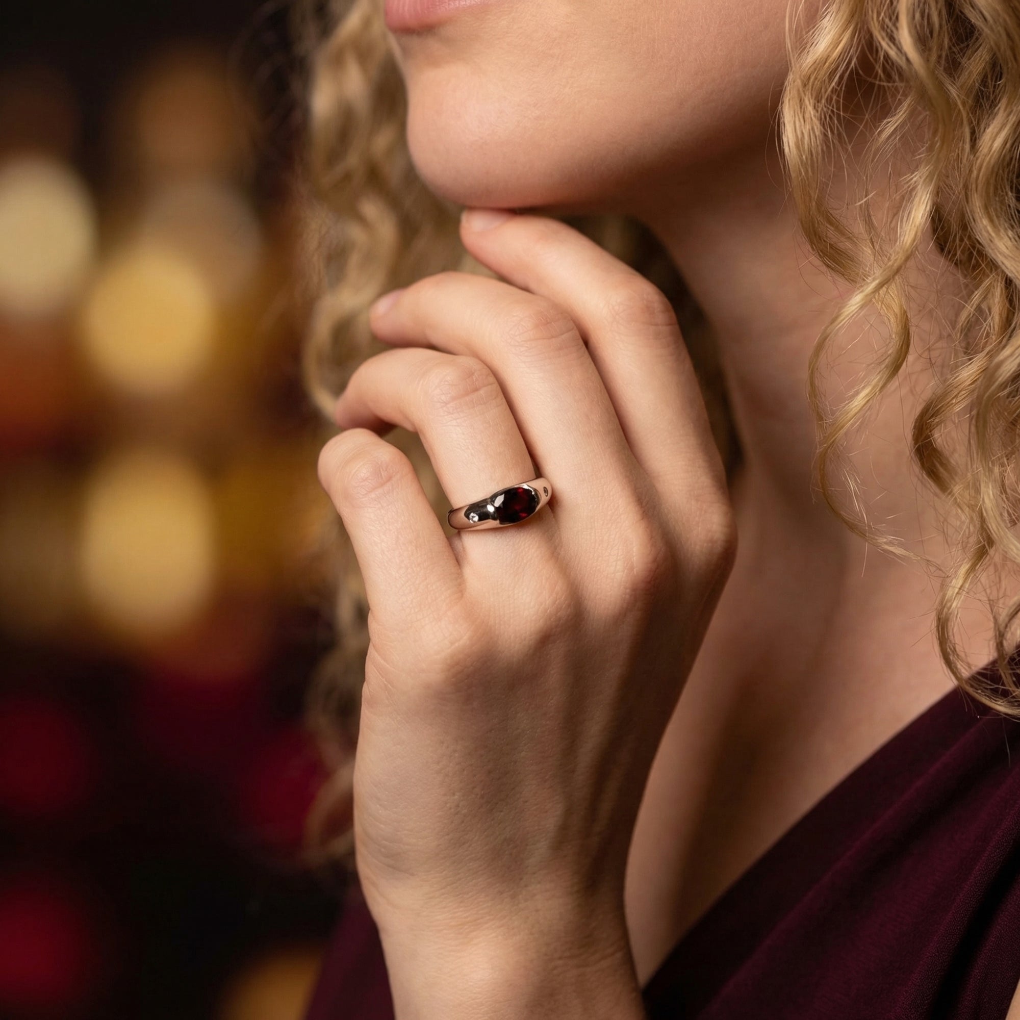 The Vaelia oval garnet ring in sterling silver worn on a model's hand.