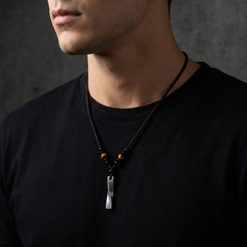 Model wearing the twisted silver bar pendant necklace over a black crewneck T-shirt.