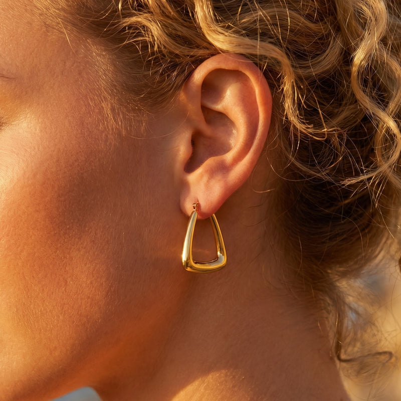 Gold 18K PVD stainless steel triangle hoop earring on ear.
