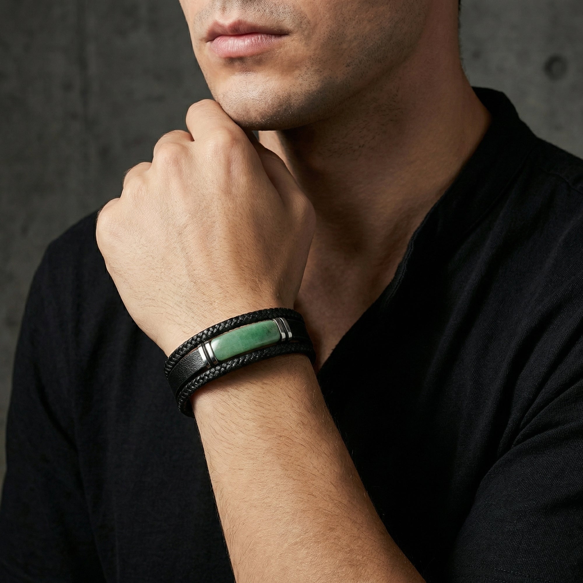 Men's Praetorian black leather bracelet with green centerpiece and 316L stainless steel hardware on a model's wrist.
