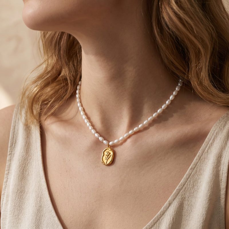 Model wearing the Rosalinde pearl necklace with a gold rose pendant and 18K gold finish.