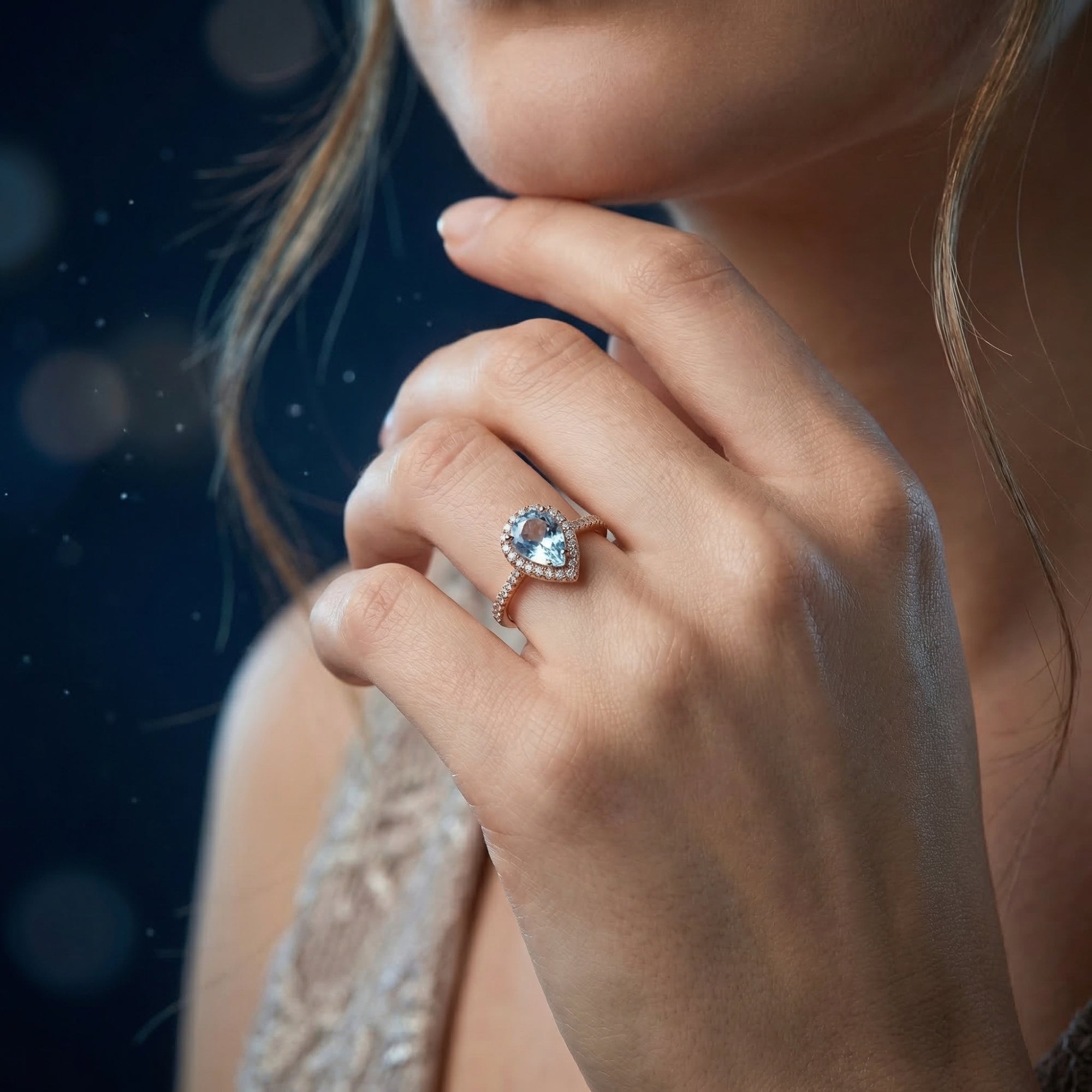 Model wearing the Lysette pear cut blue topaz ring in 18K rose gold vermeil, showcasing its elegant design.