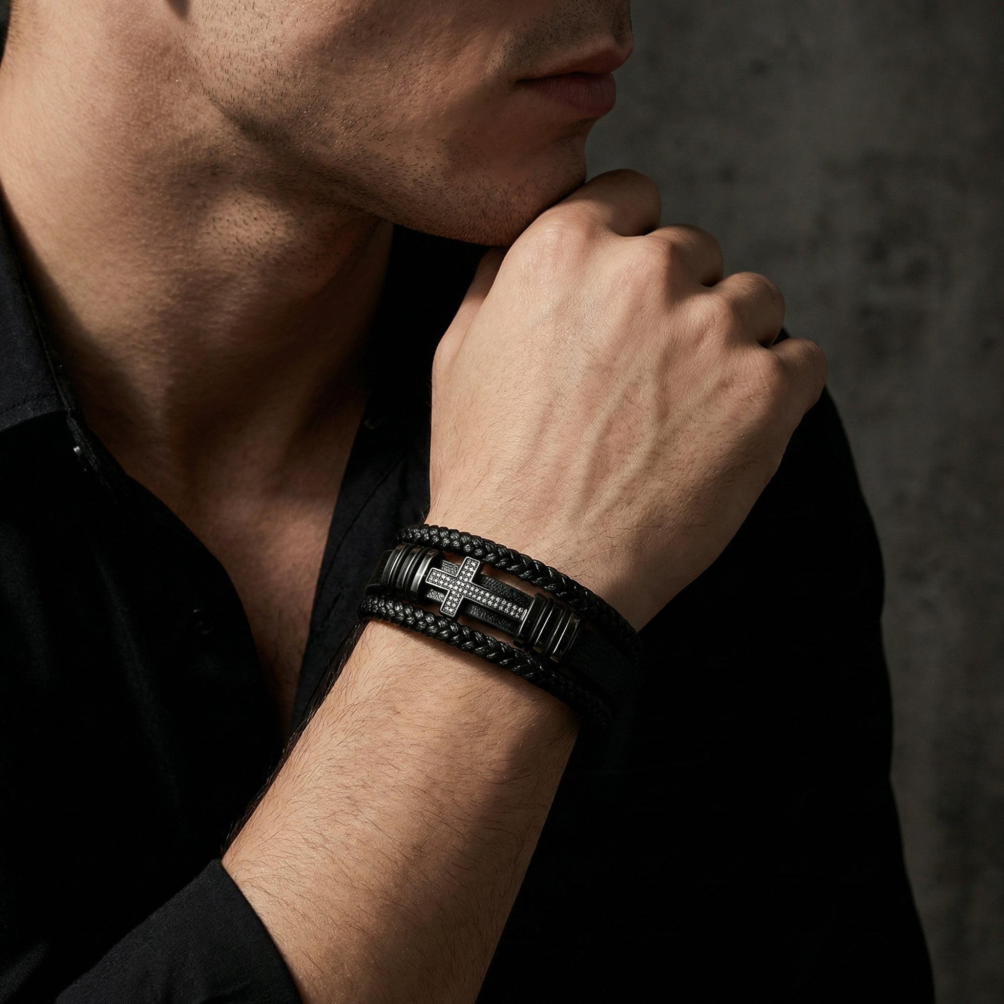 Men's black leather Ironcross bracelet with a black PVD steel cross worn on a model's wrist.