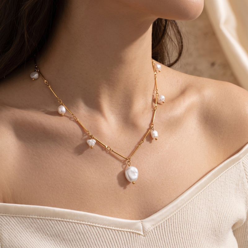 Model wearing the gold finish Henrietta pearl necklace with irregular baroque pearls on a sleek chain.