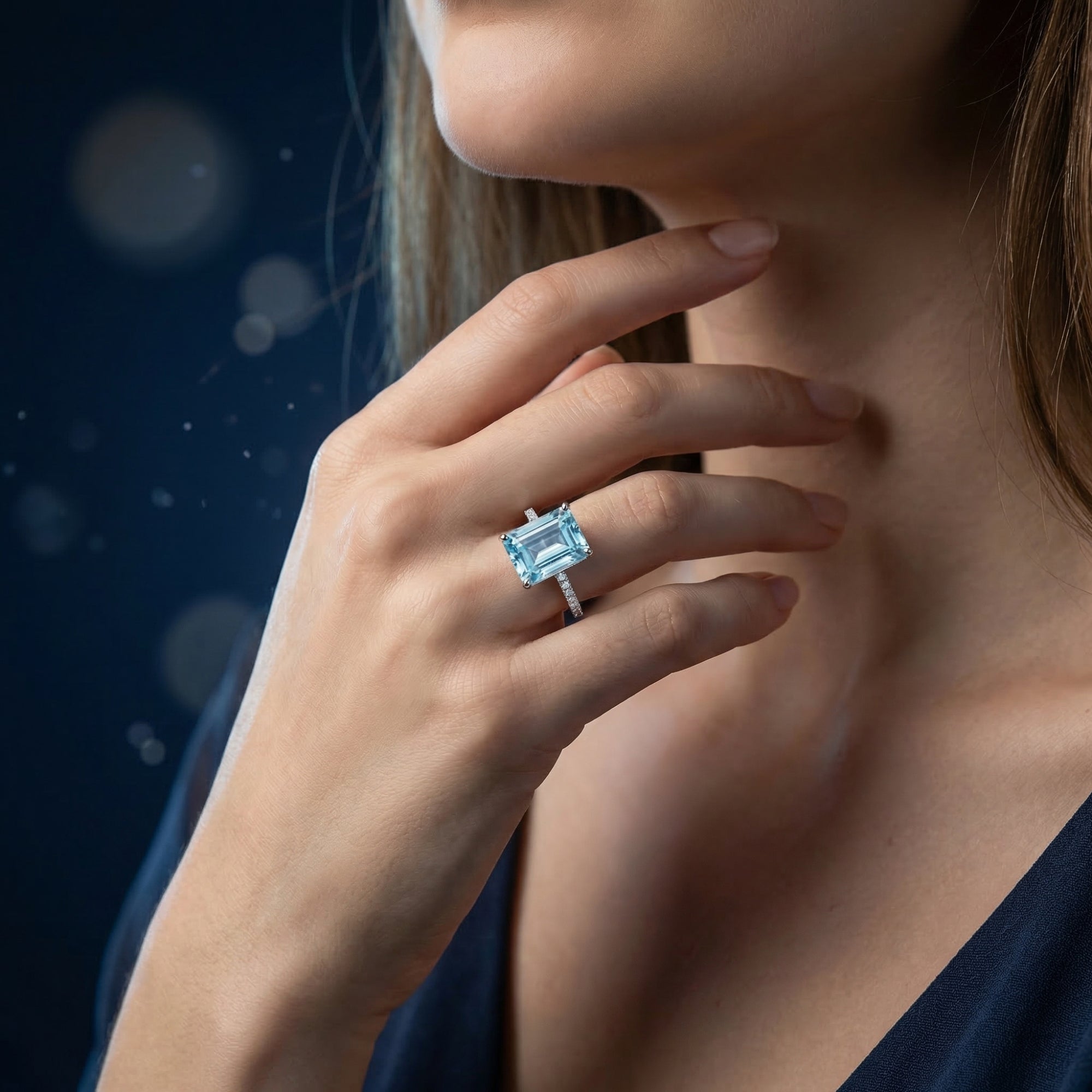 Woman wearing the emerald cut natural blue topaz sterling silver ring on her finger.