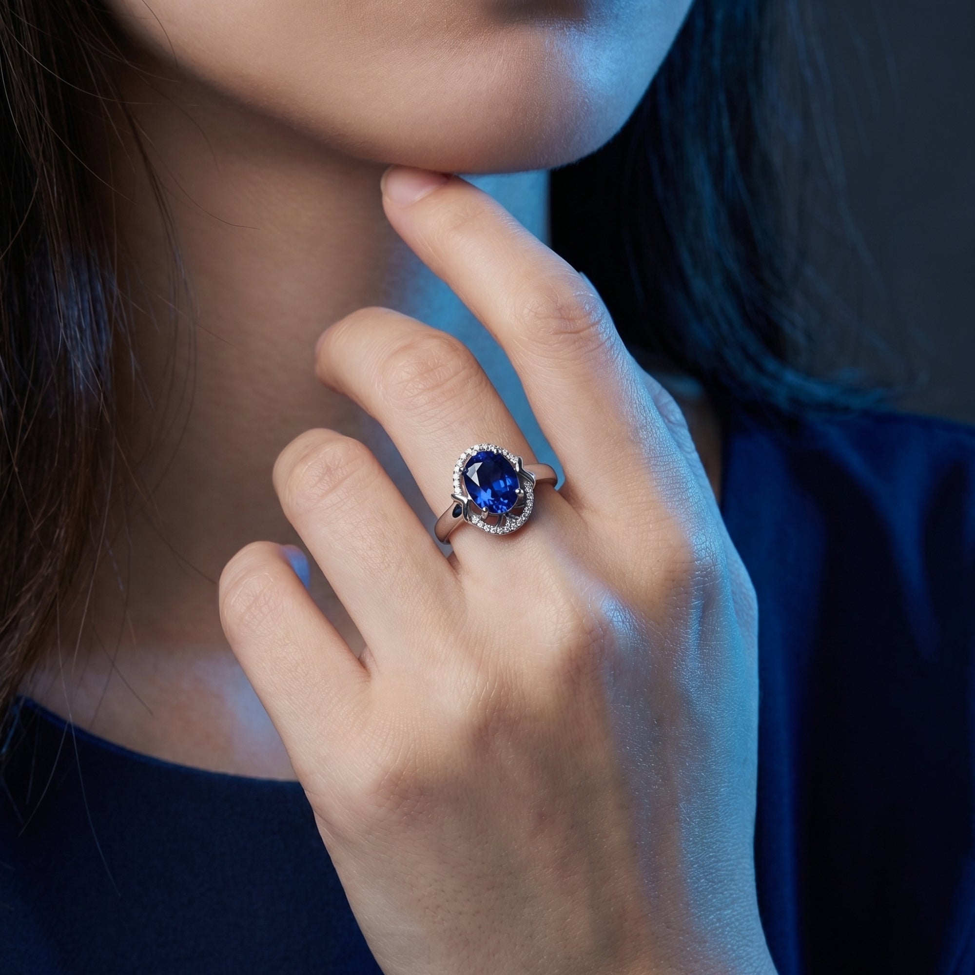Model wearing the 18K white gold Karyna oval tanzanite and diamond halo ring on her ring finger.