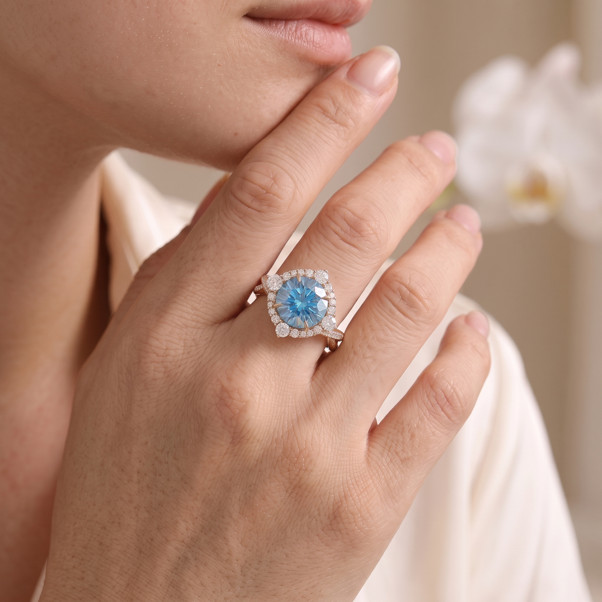 Model wearing a rose gold blue moissanite halo ring on her finger.