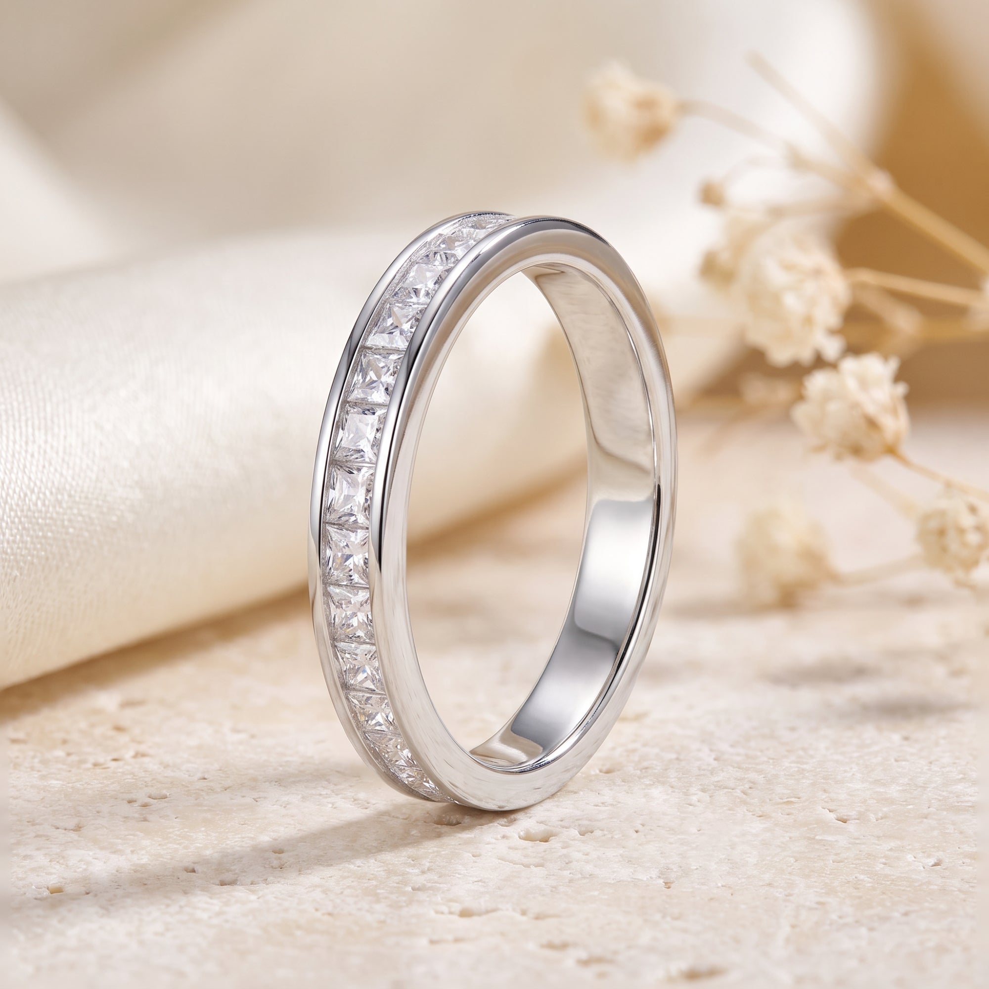 Macro view of a sterling silver channel-set eternity ring with princess cut cubic zirconia.
