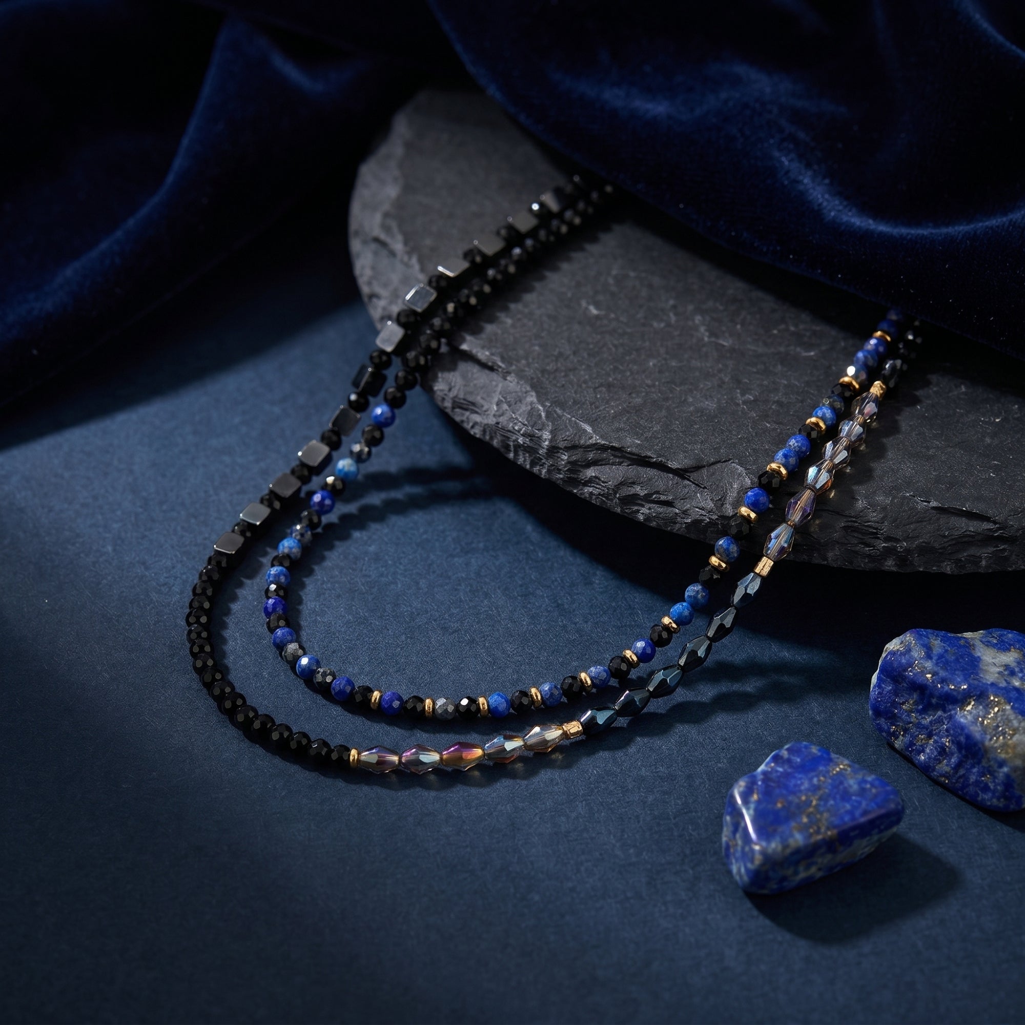 Macro view of natural lapis lazuli, black faceted, and iridescent beads on a gold-plated necklace set.