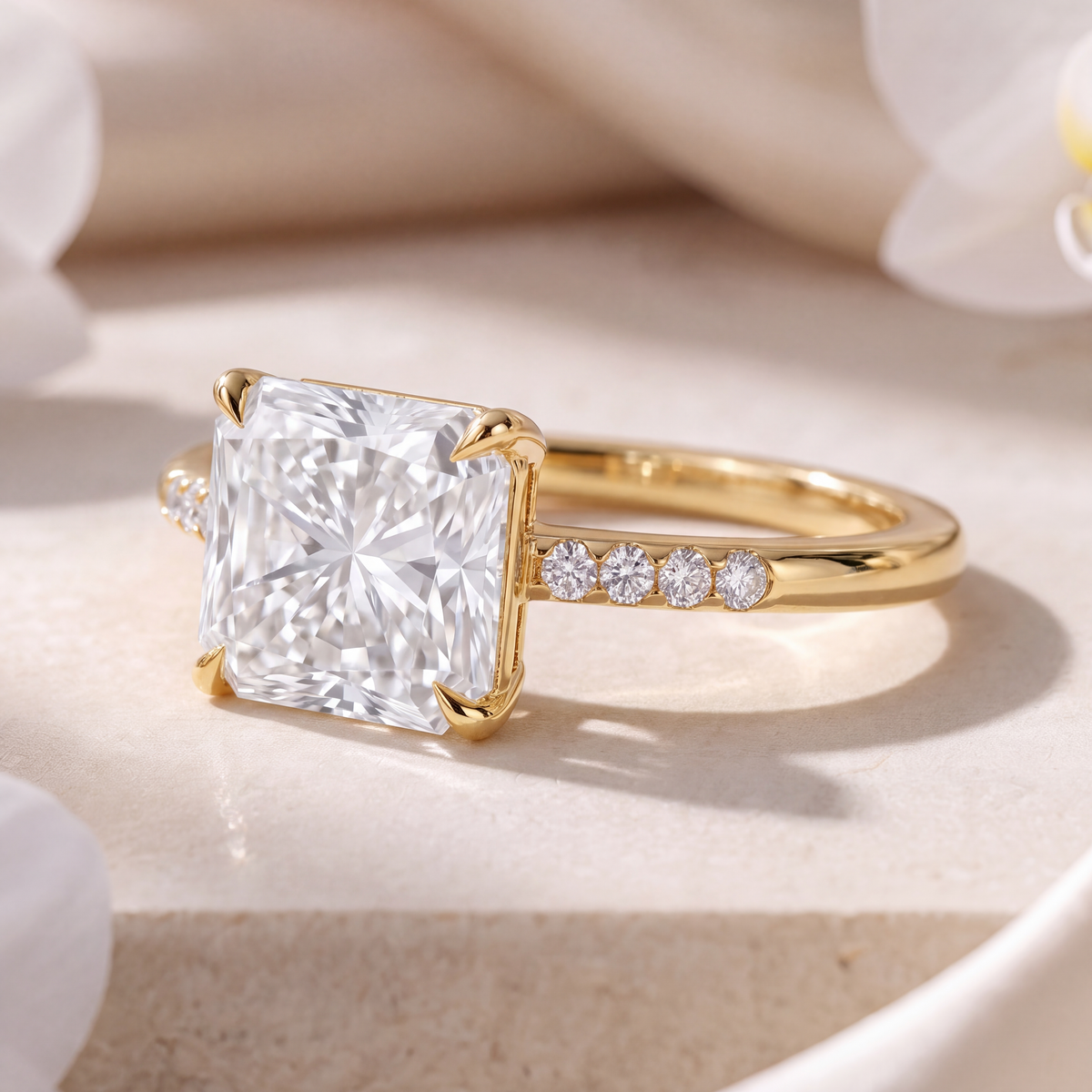 Side view of a yellow gold radiant cut moissanite engagement ring featuring a pavé band.