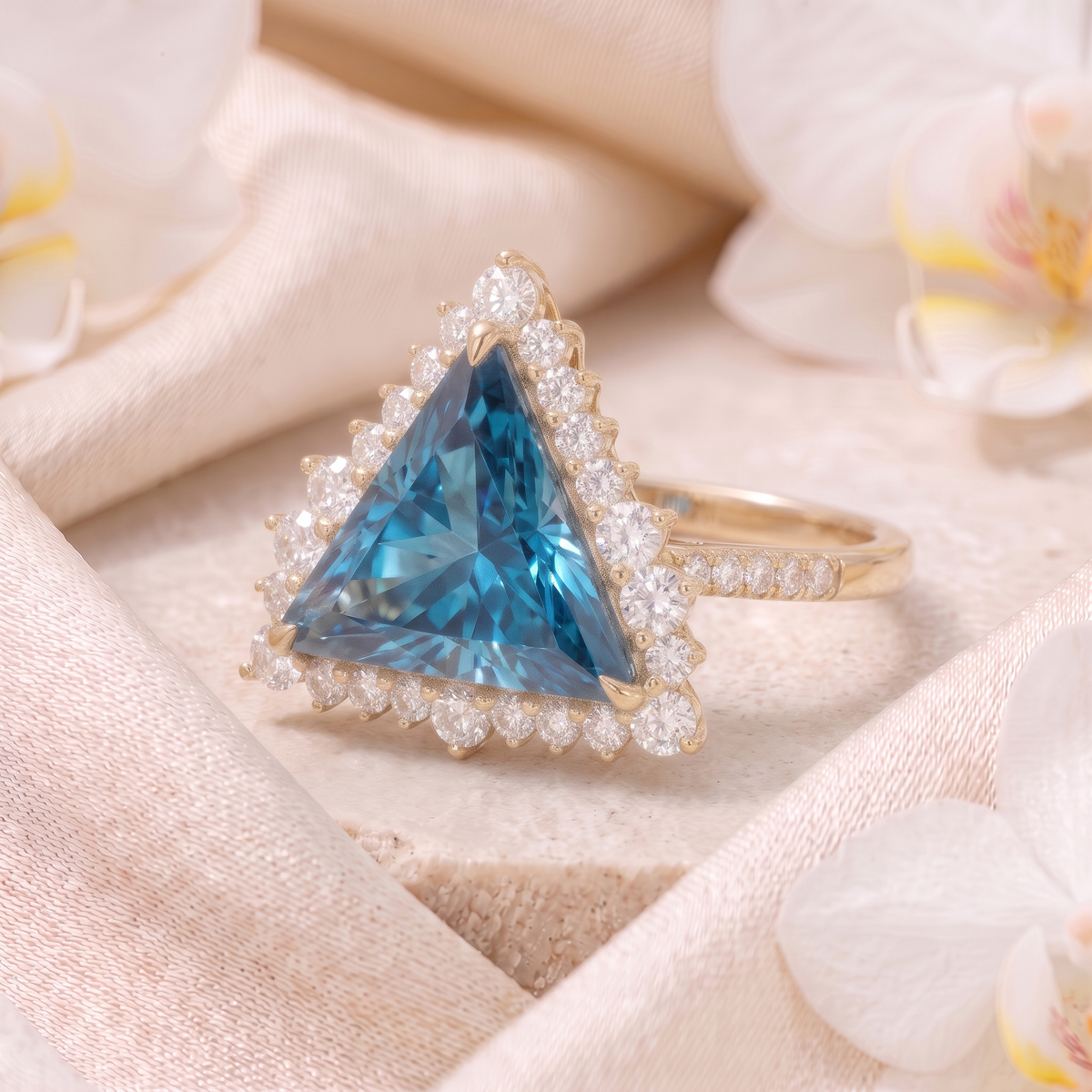 Angled perspective view of a trillion cut blue moissanite halo ring in yellow gold.