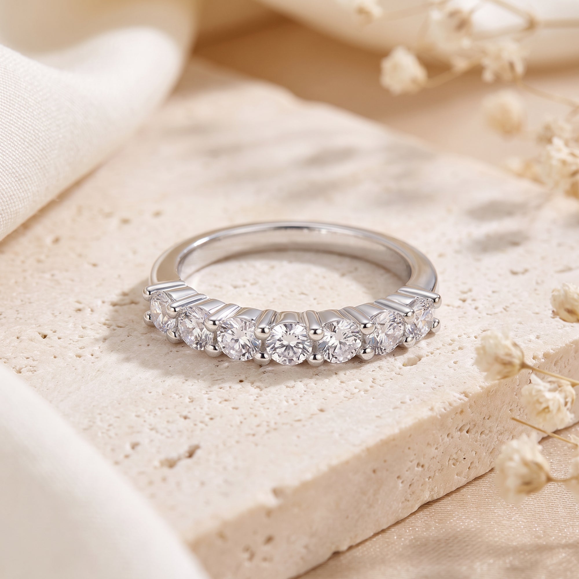 Close-up of a seven-stone S925 sterling silver eternity band showing shared-prong round-cut stones.