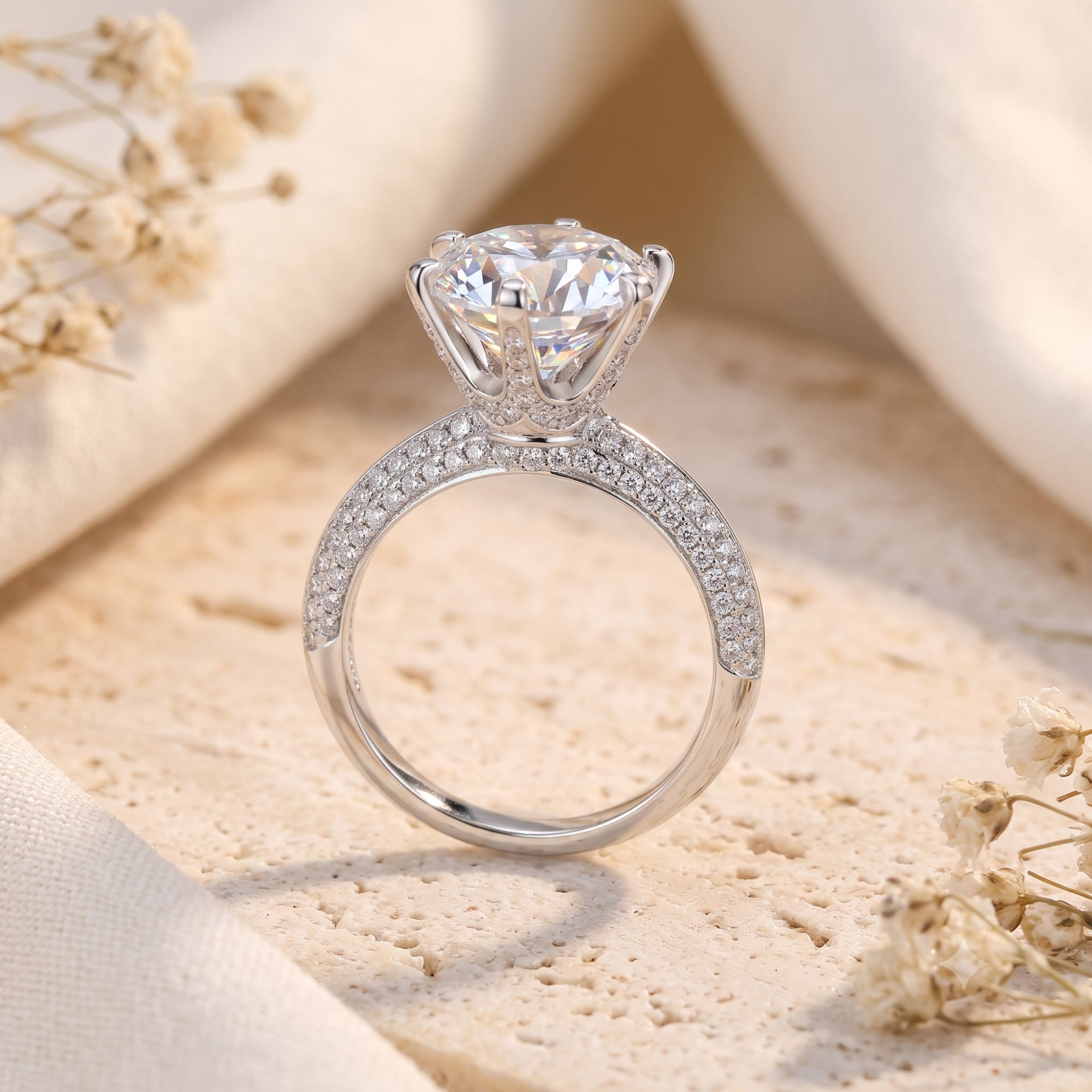 Side view of silver crown solitaire ring showing the six-prong setting and pavé-set stones.