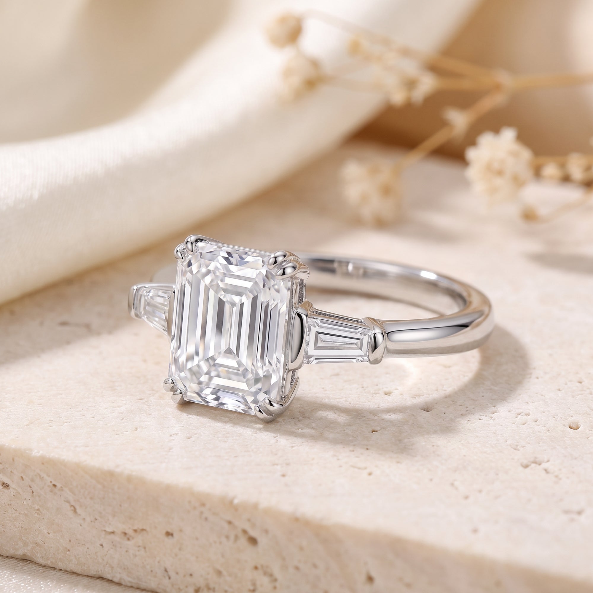 Detail of emerald cut cubic zirconia and baguette stones in a silver prong setting.