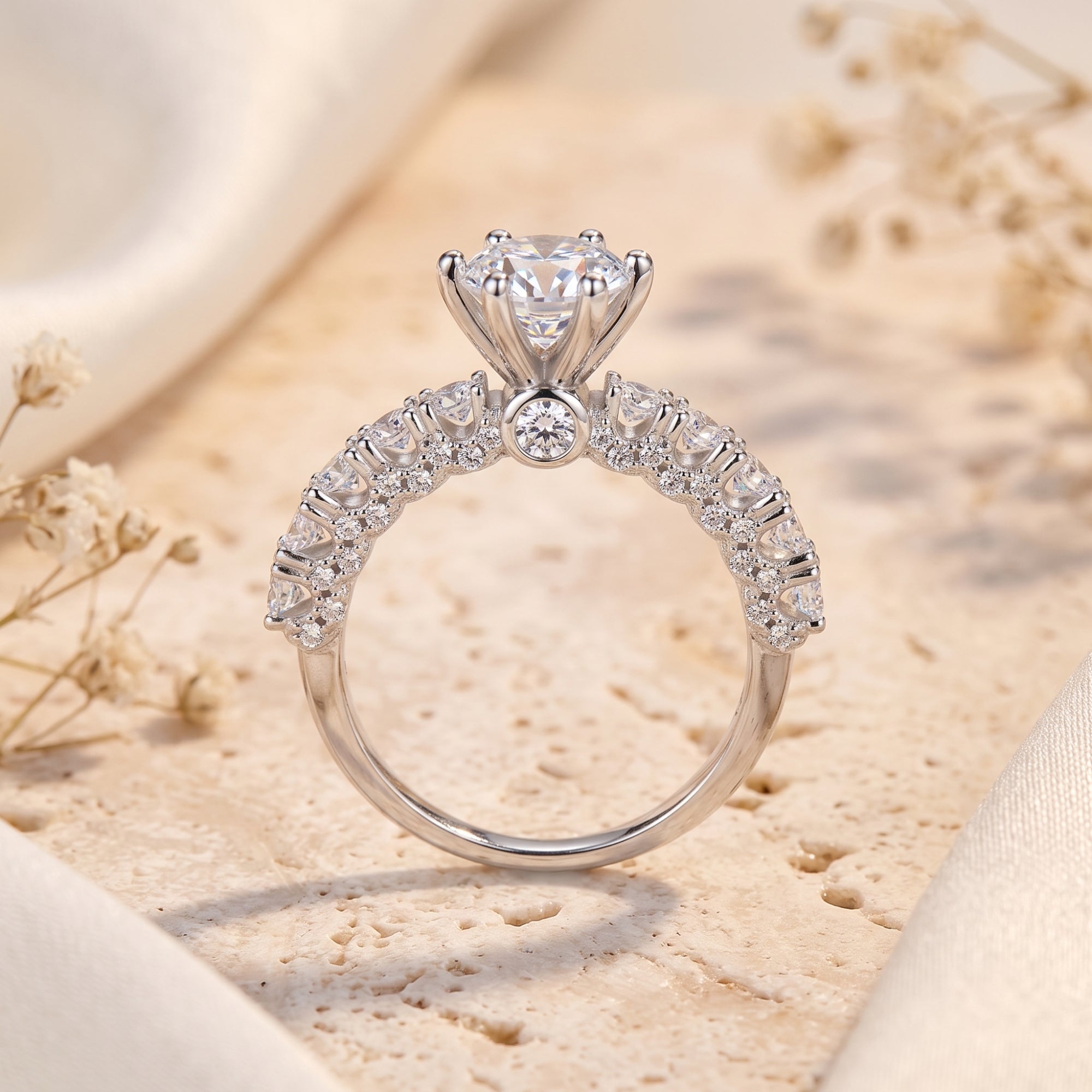 Close-up of silver cathedral ring showing six-prong crown setting and side stones.