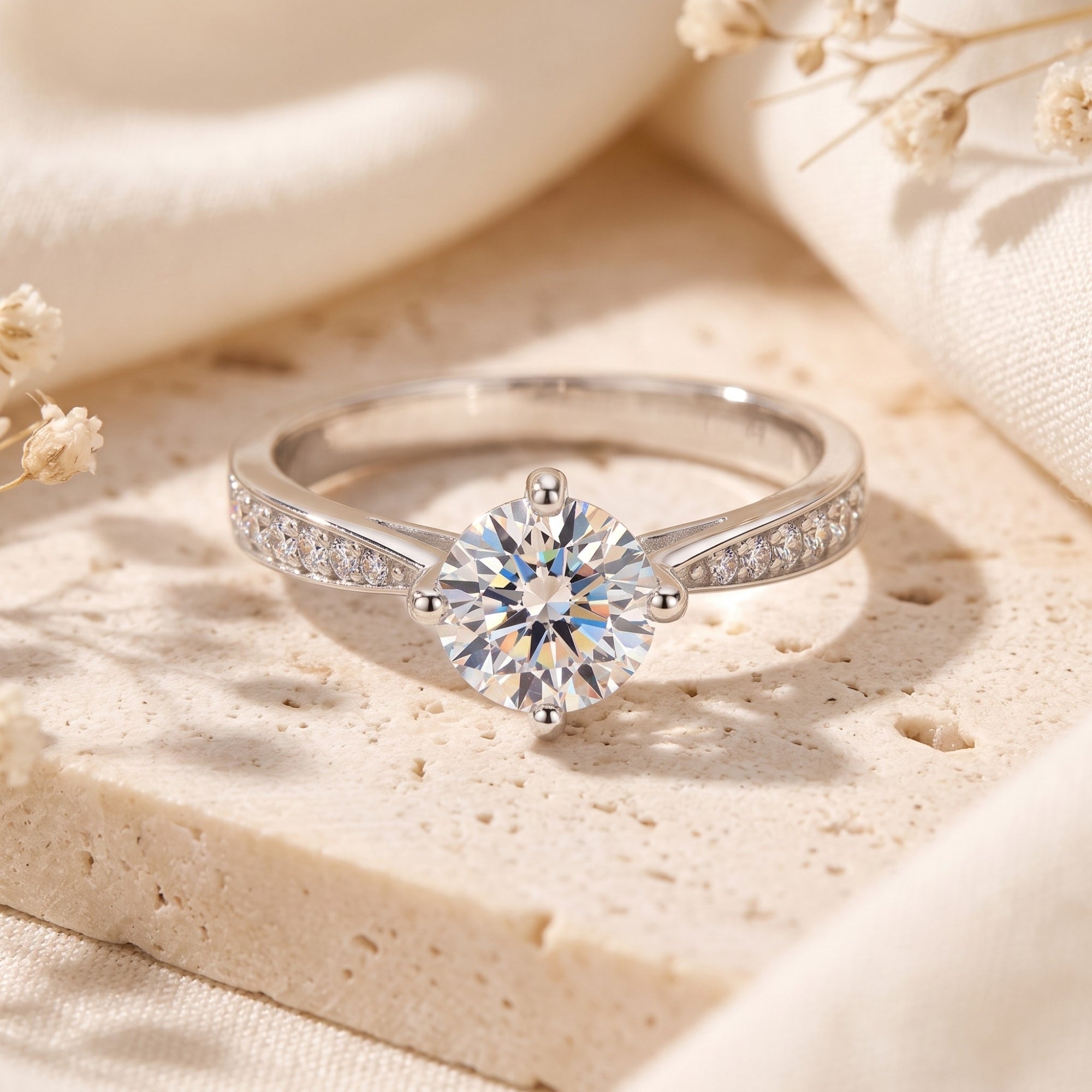 Front view of a sterling silver 6.5mm round cut cubic zirconia solitaire ring on a neutral stone background.